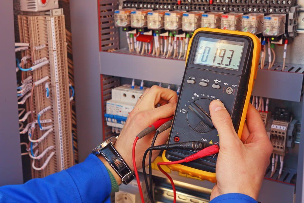 A Person is Holding a Digital Multimeter in Their Hands — NQBC Pty Ltd in Bowen, QLD