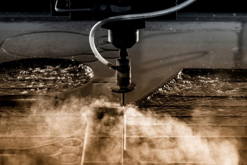A Machine is Cutting a Piece of Metal With Water — NQBC Pty Ltd in Emerald, QLD