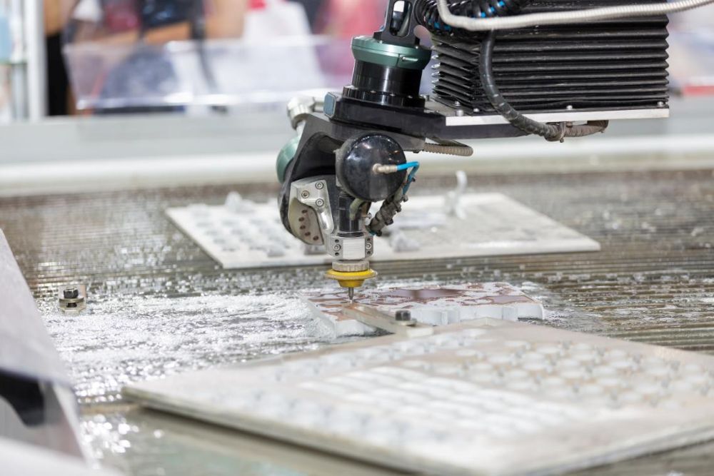 A Machine is Cutting a Piece of Tile With Water — NQBC Pty Ltd in Ayr, QLD