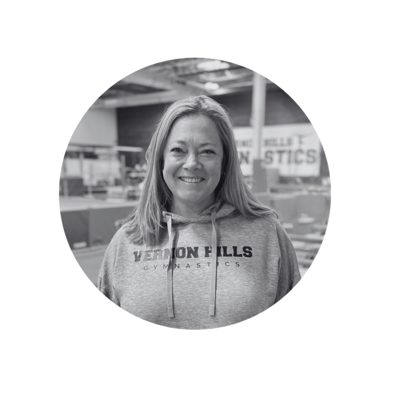 Smiling person in a Vernon Hills hoodie standing indoors with blurred store shelves behind.