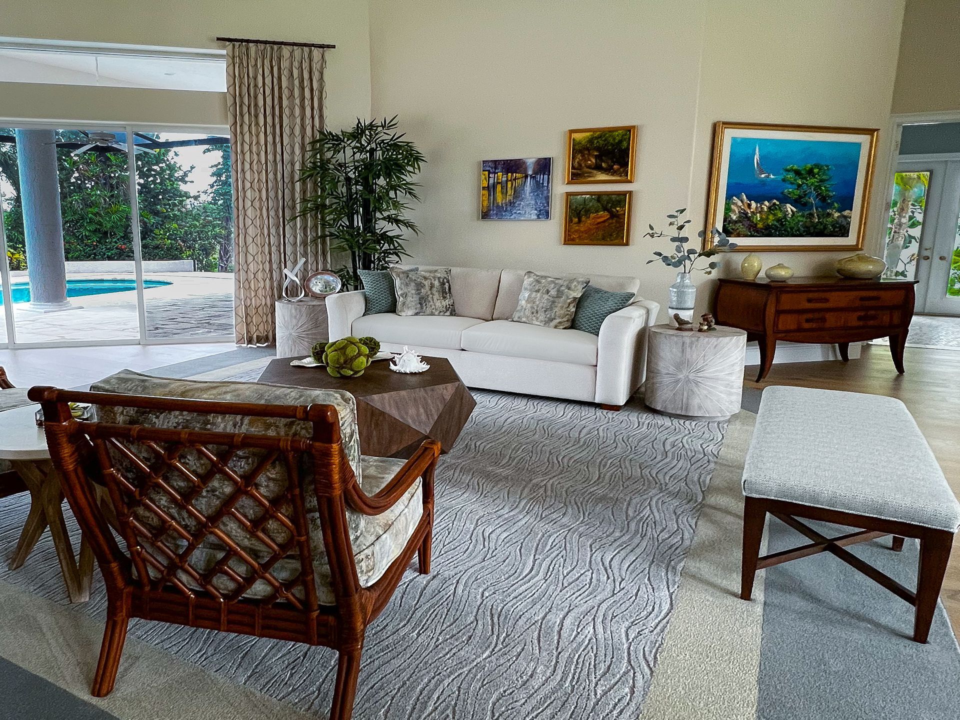Living room with white sofa, art, bamboo, and decorative objects.