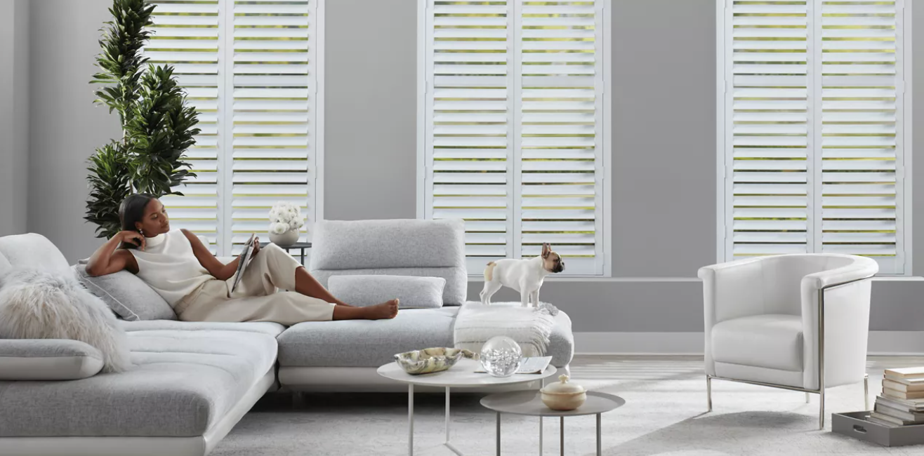 Hunter Douglas composite shutters covering three living room windows.