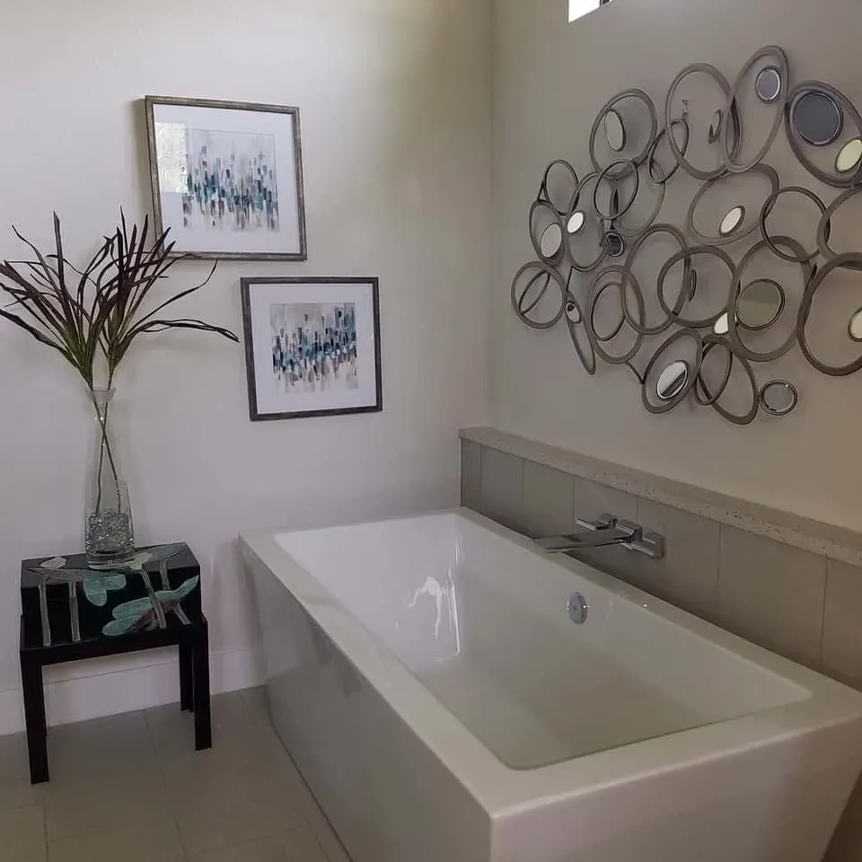 Modern bathroom with a white bathtub, artwork, and decorative accents.