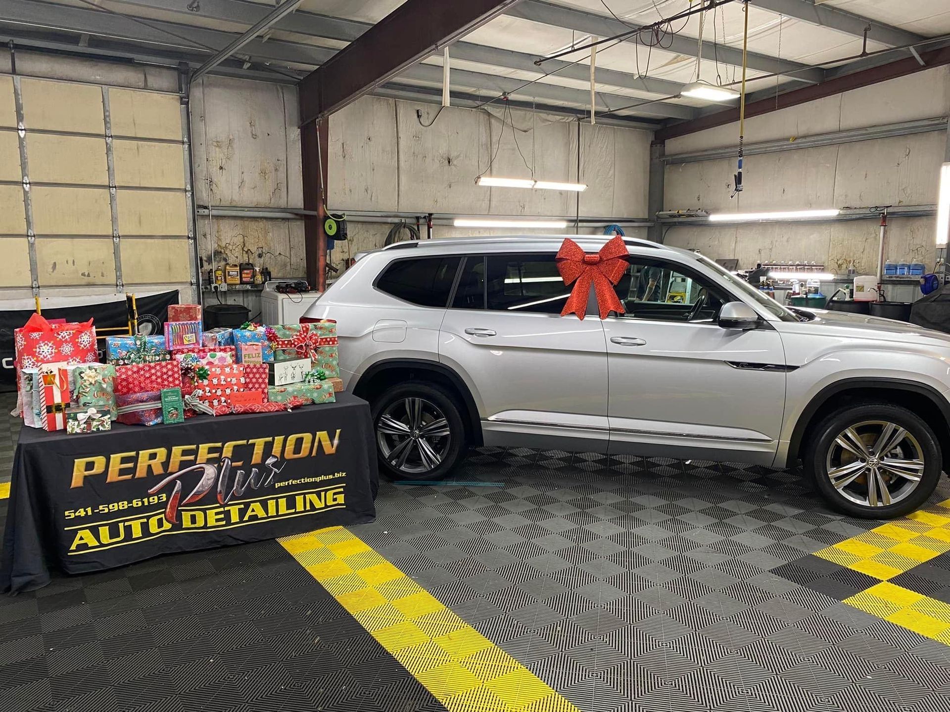 Silver SUV with a red bow, gifts, and