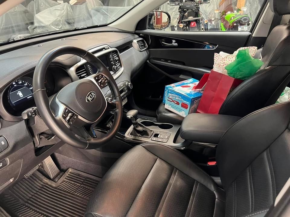 Interior view of a Kia Sorento car with presents in the front seat.