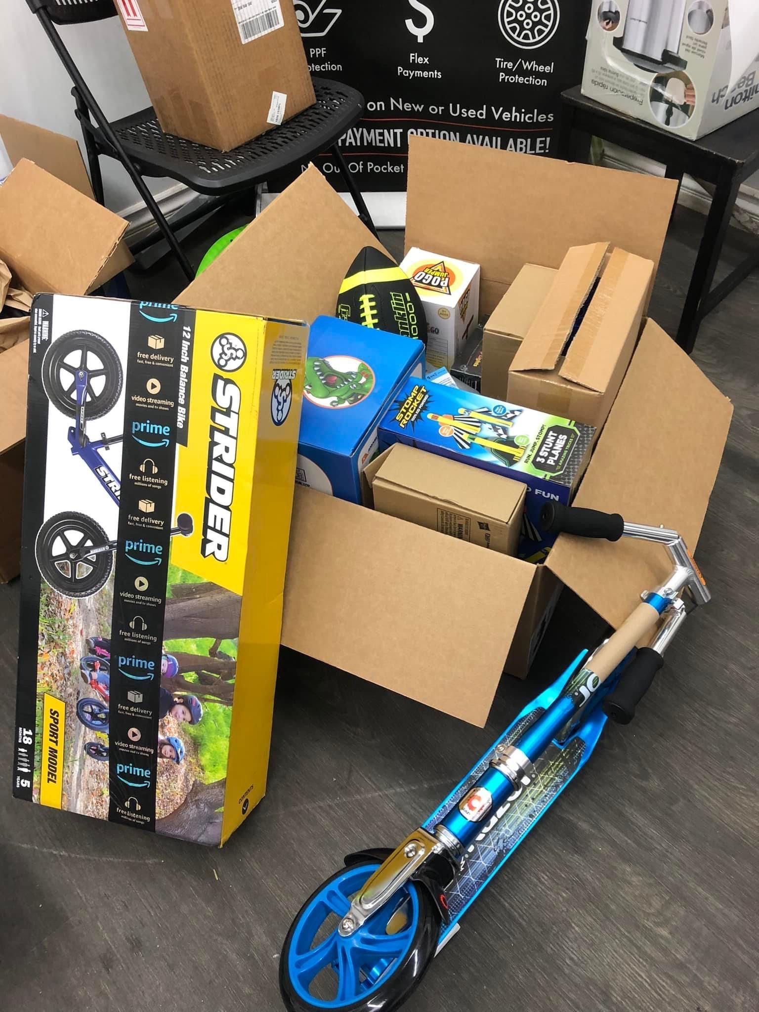 Boxes, a scooter, and a folded cardboard box in an indoor setting.