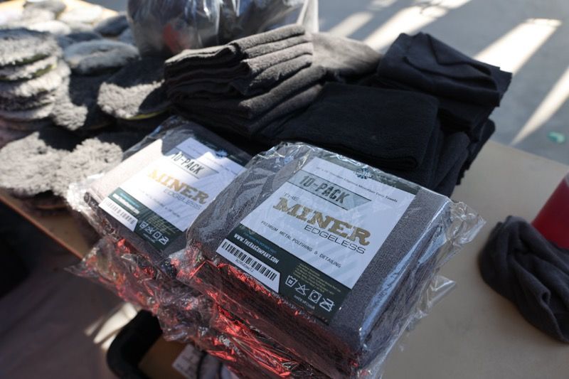 Bundled cleaning cloths and pads on a table, possibly for a car wash.