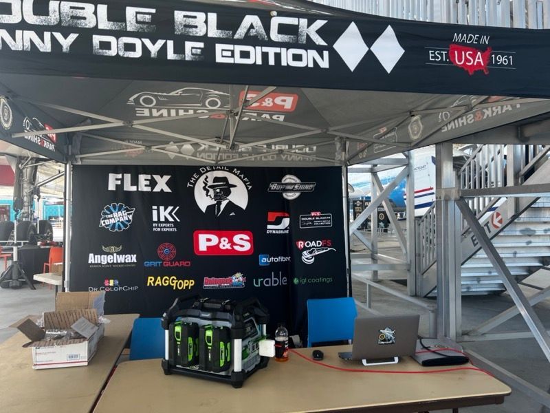 A tent display with logos and products at an outdoor event. 