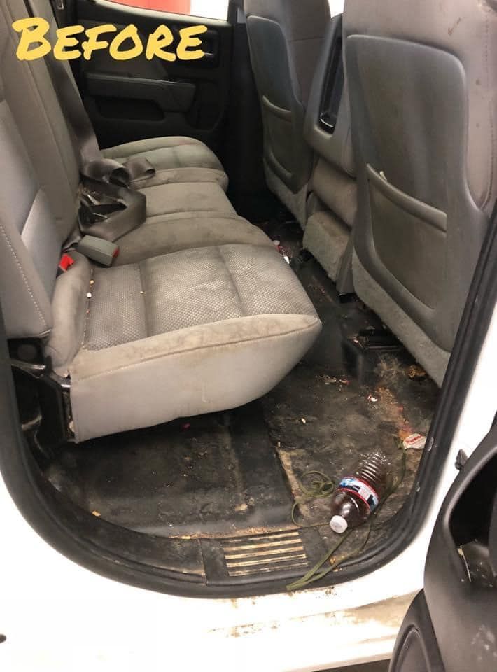 Dirty truck interior before cleaning, showing stained seats and debris on the floor.