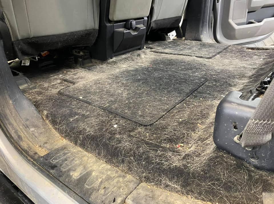Dirty truck interior with floor covered in dirt and debris.
