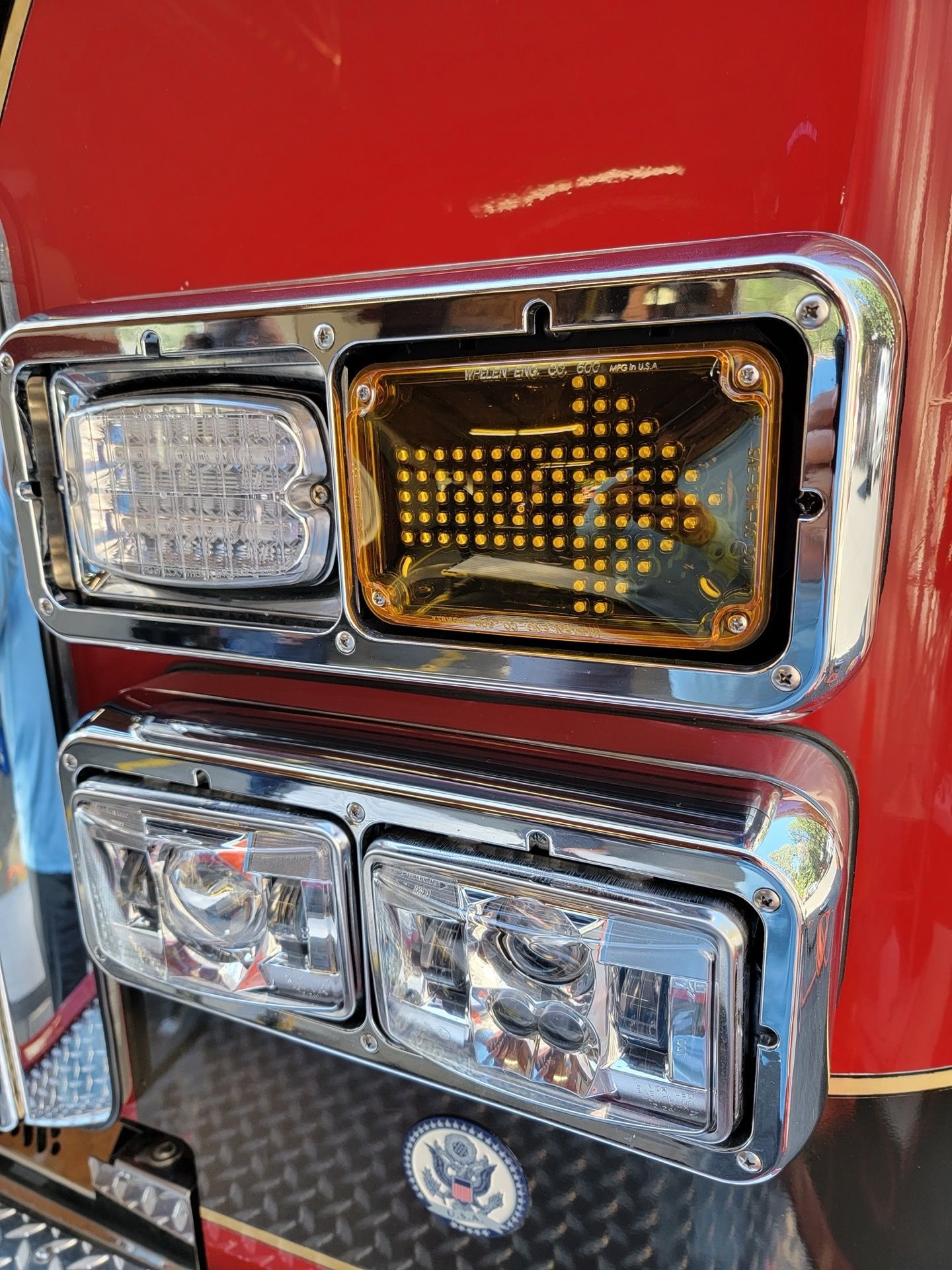 Close-up of a fire truck's front lights. A clear LED light, amber LED light and two headlights are visible.
