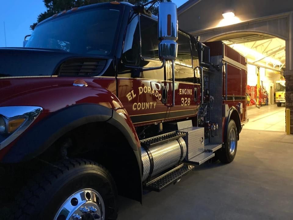 Red and black El Dorado County fire engine parked in a bay.