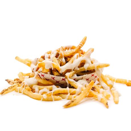 Pile of french fries, covered in white sauce, spilling out of a red and white patterned bowl.