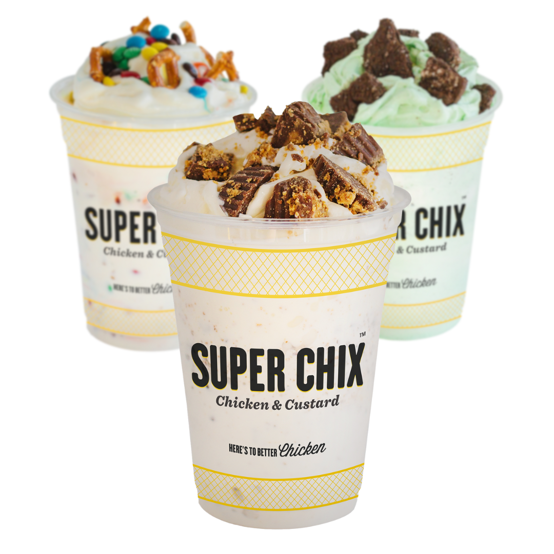 Three Super Chix custard shakes: topped with candy, sprinkles, and nuts, in a yellow-striped cup.