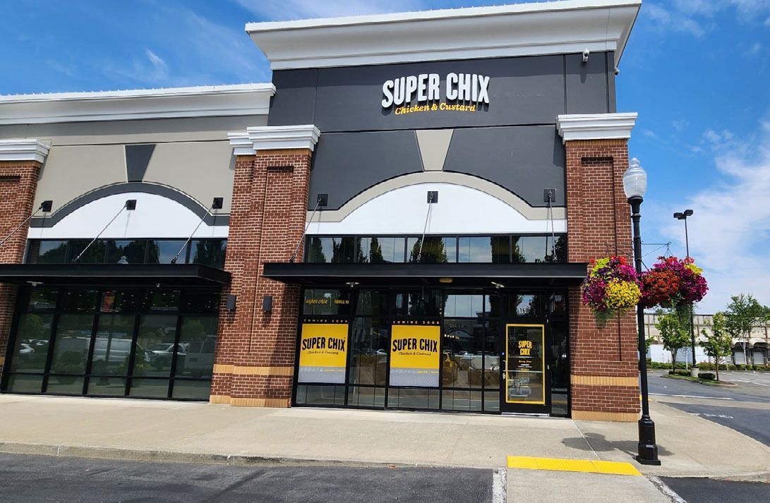Super Chix restaurant storefront with brick accents and large windows.