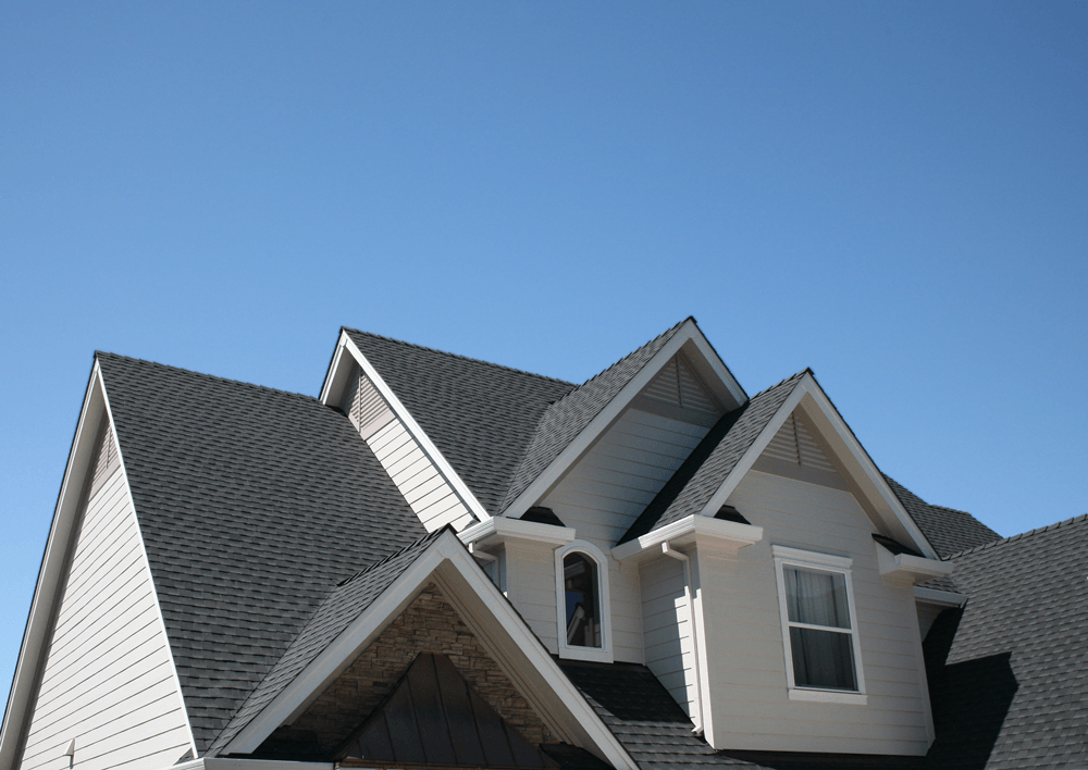 The roof of a house with a blue sky in the background