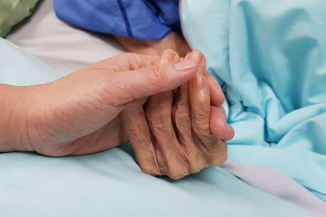 young woman holding old woman's hand