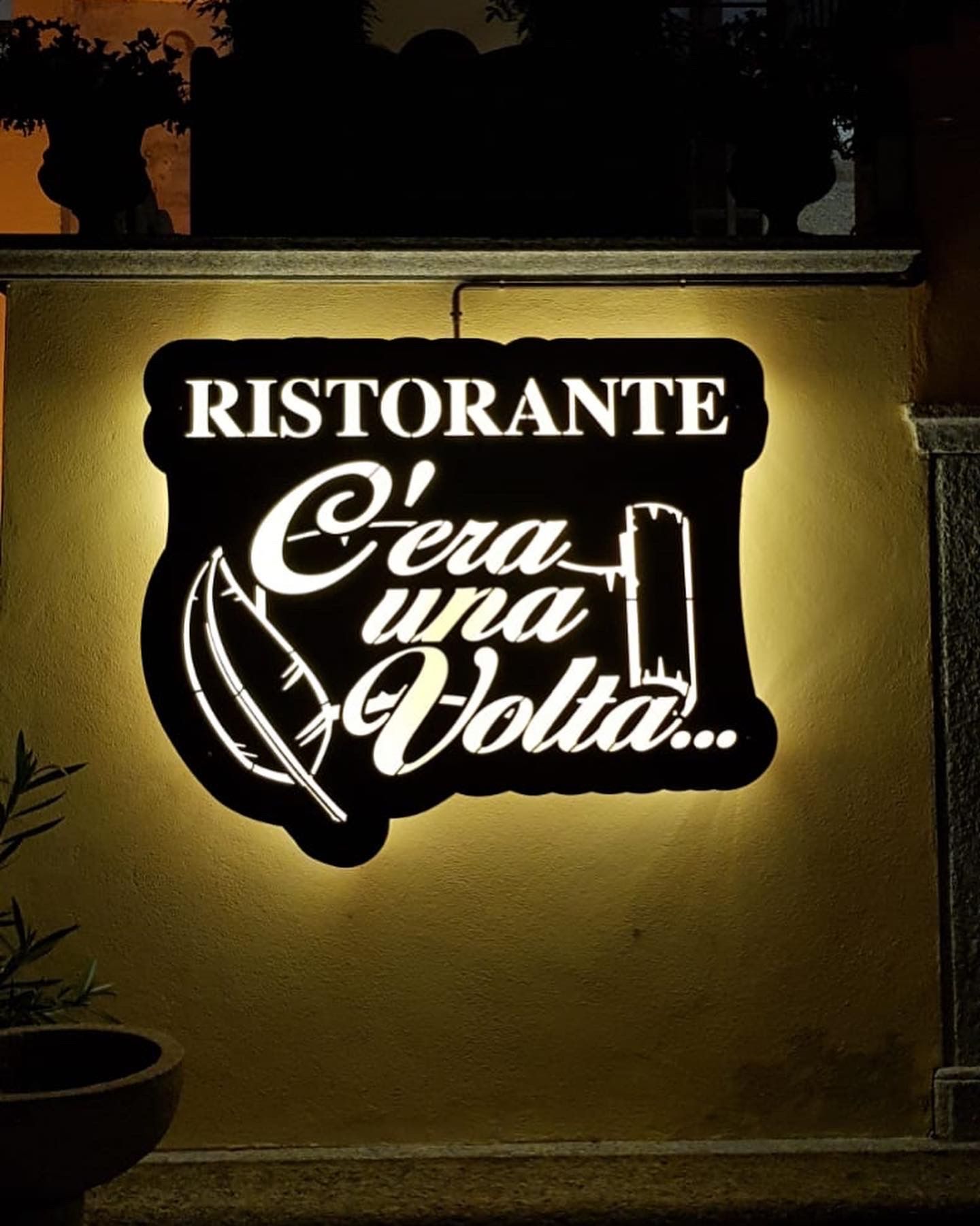 Un'insegna scura retroilluminata, ritagliata e con la scritta 