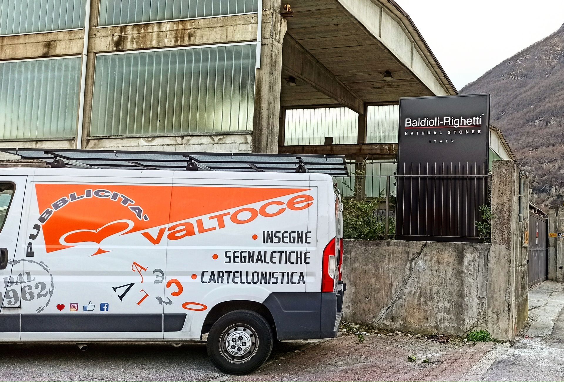 Un furgone bianco da lavoro con la scritta arancione 