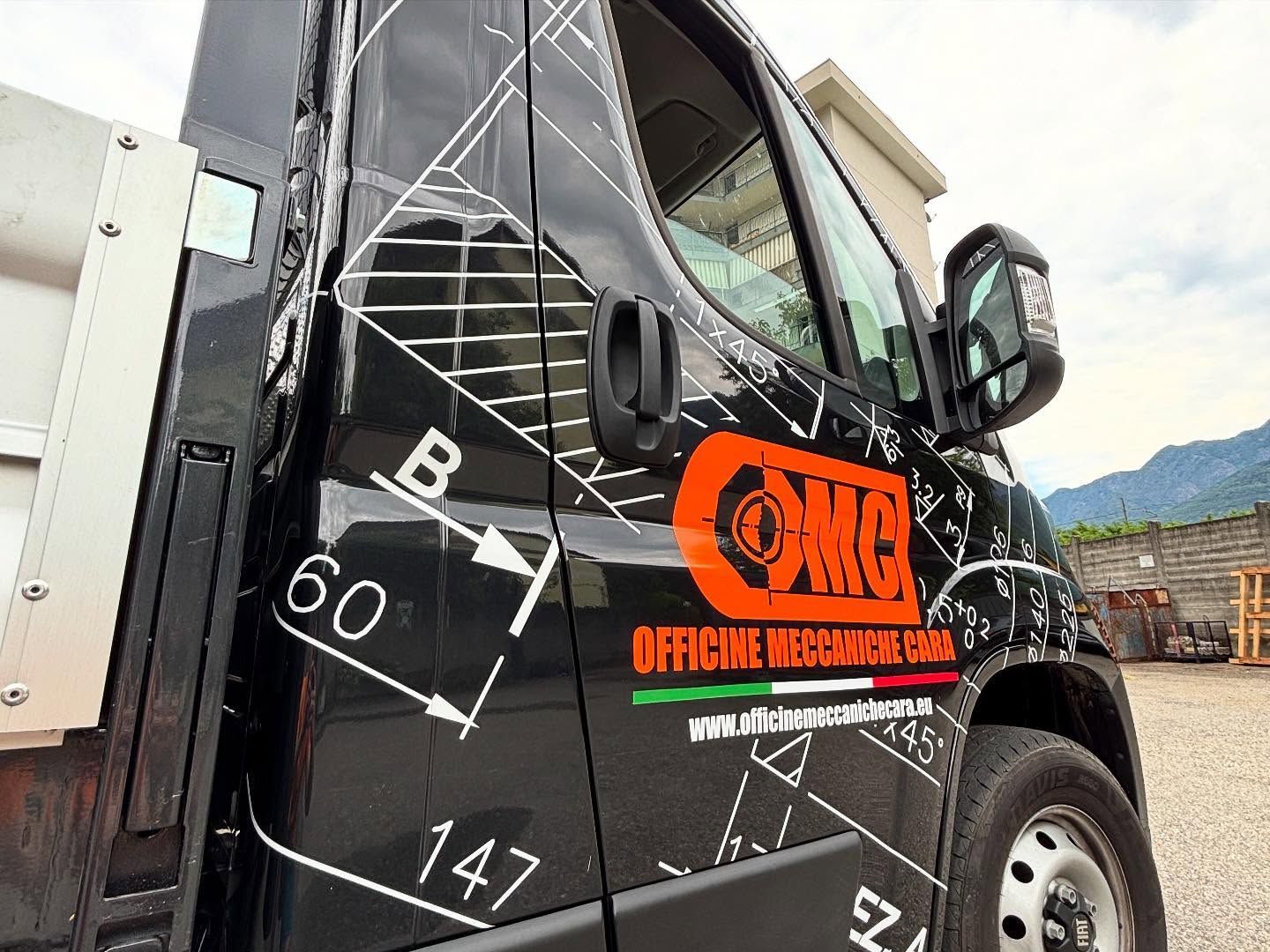 Sportello nero per camion con grafica tecnica bianca, logo aziendale arancione e un dettaglio con la bandiera italiana.
