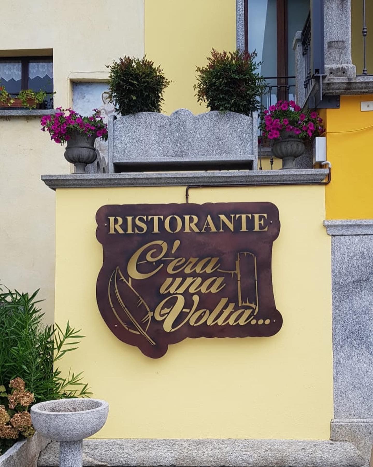 Su un muro giallo, l'insegna di un ristorante recita 