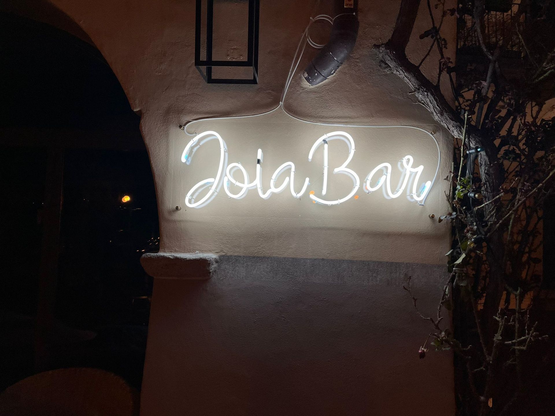 Di notte, su una parete ruvida, un'insegna al neon luminosa recita 