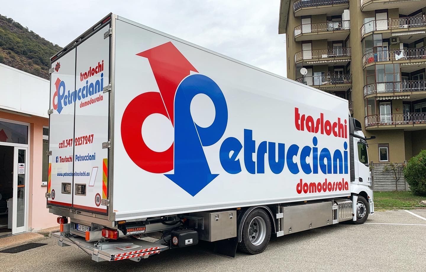 Un furgone bianco parcheggiato all'aperto, con il logo della ditta di traslochi 