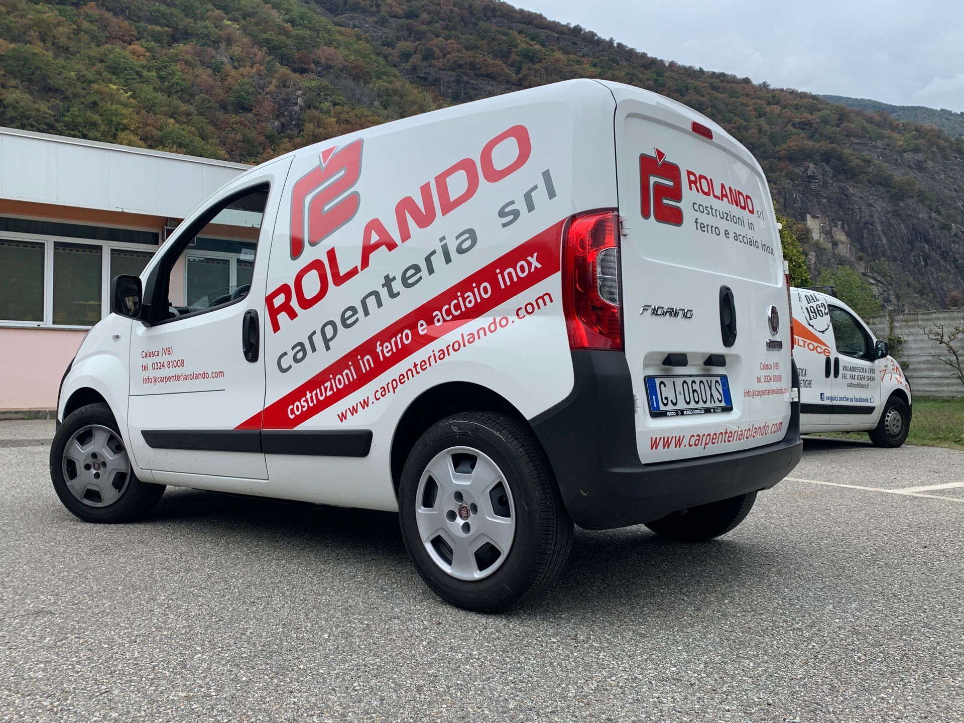 Furgone bianco della Rolando Carpenteria srl ​​parcheggiato all'aperto con il logo aziendale, visto da un'angolazione di tre quarti posteriore.
