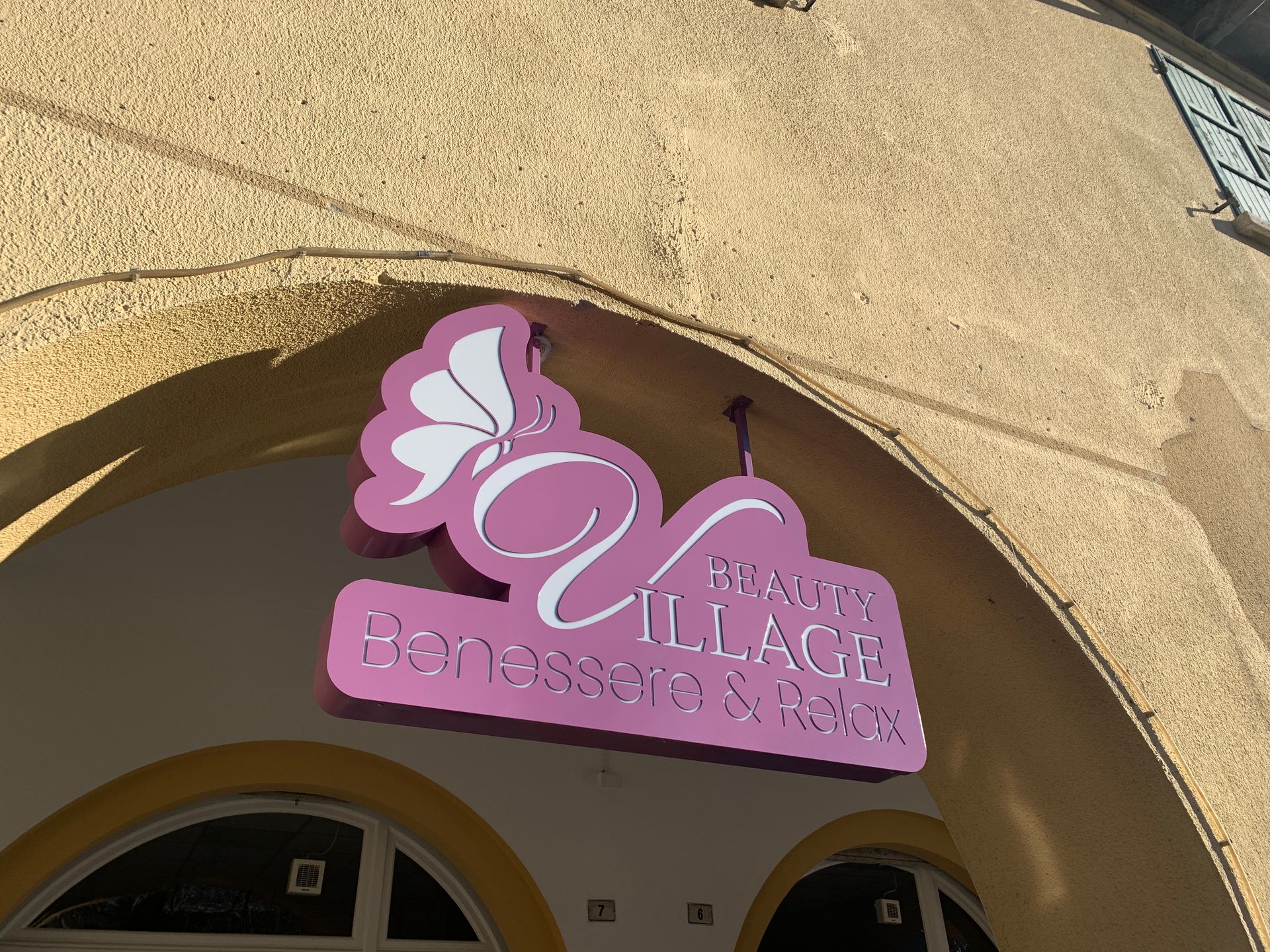 Un'insegna rosa a forma di farfalla con la scritta 