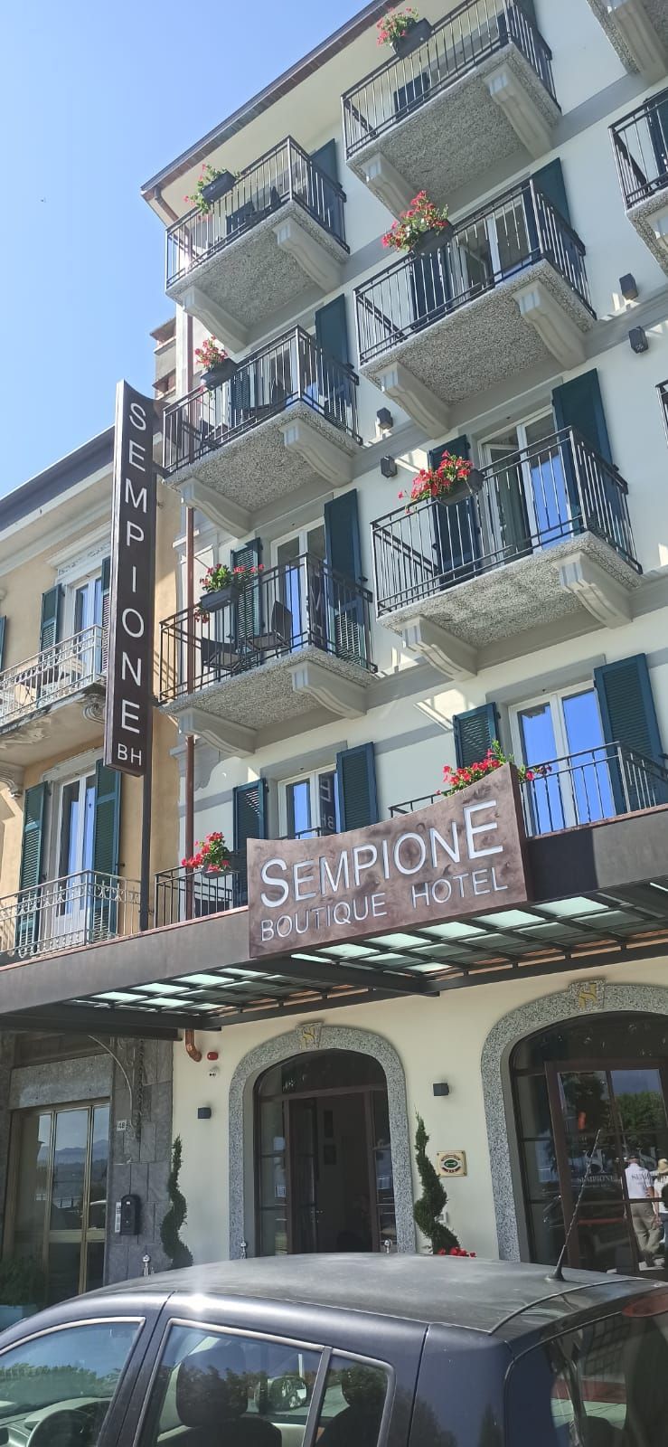 Un edificio alto, color crema, con diversi balconi e un'insegna con la scritta 