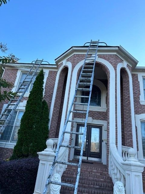 A ladder is sitting in front of a large brick house.