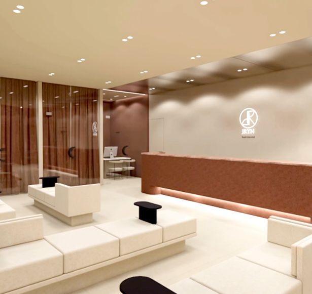 Modern minimalist lobby with cream seating, wood accents, and warm recessed lighting