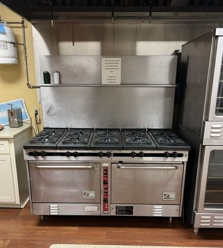 A large stainless steel stove with two ovens in a kitchen