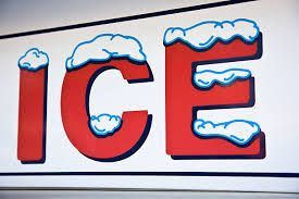A red and white sign that says `` ice '' with snow on it.