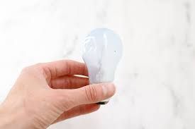 A person is holding a light bulb in their hand.