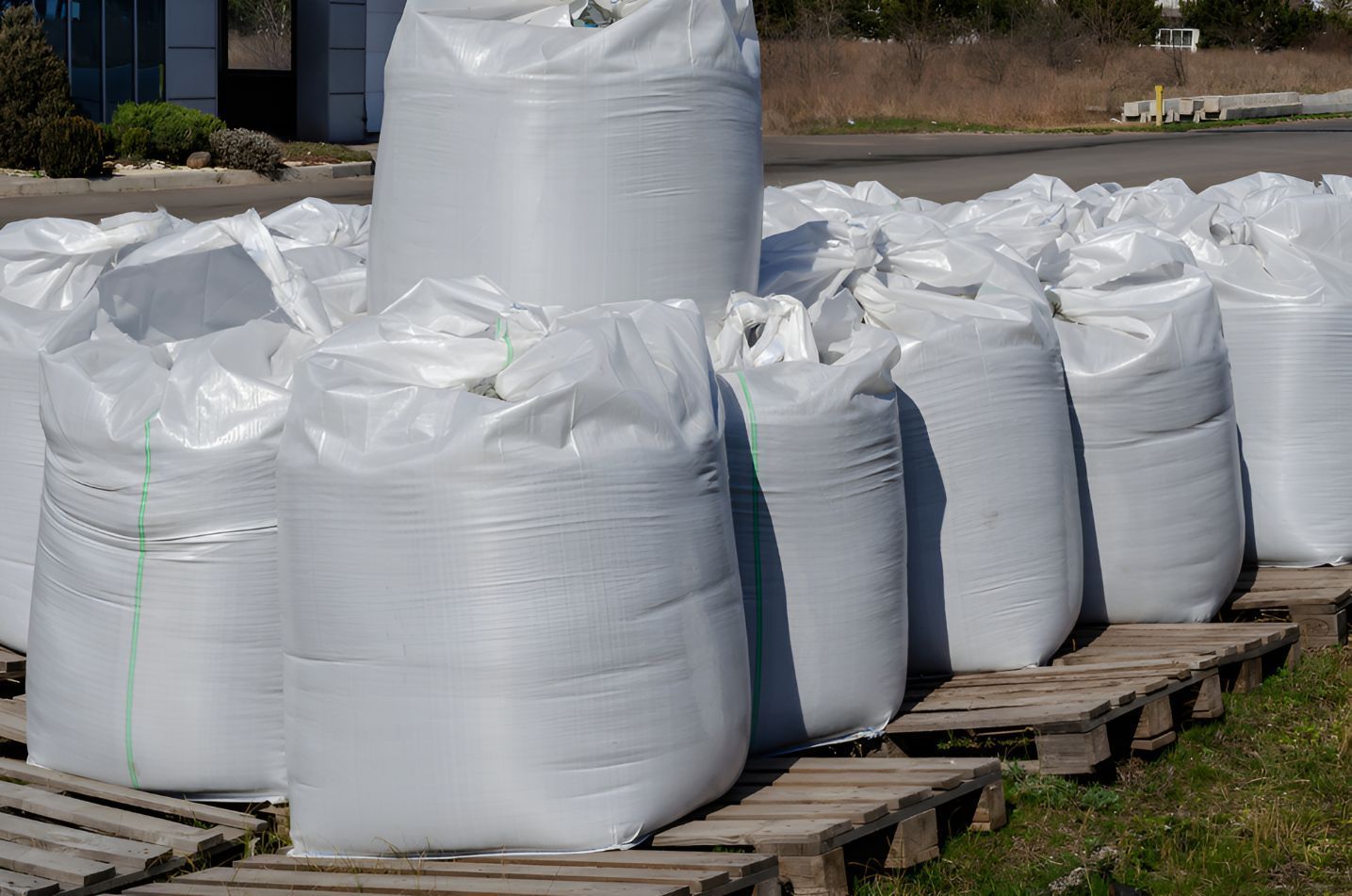 A Row Of White Bags Sitting On Top Of Wooden Pallets — Belt Maintenance & Supplies Pty Ltd In Nindaroo, QLD