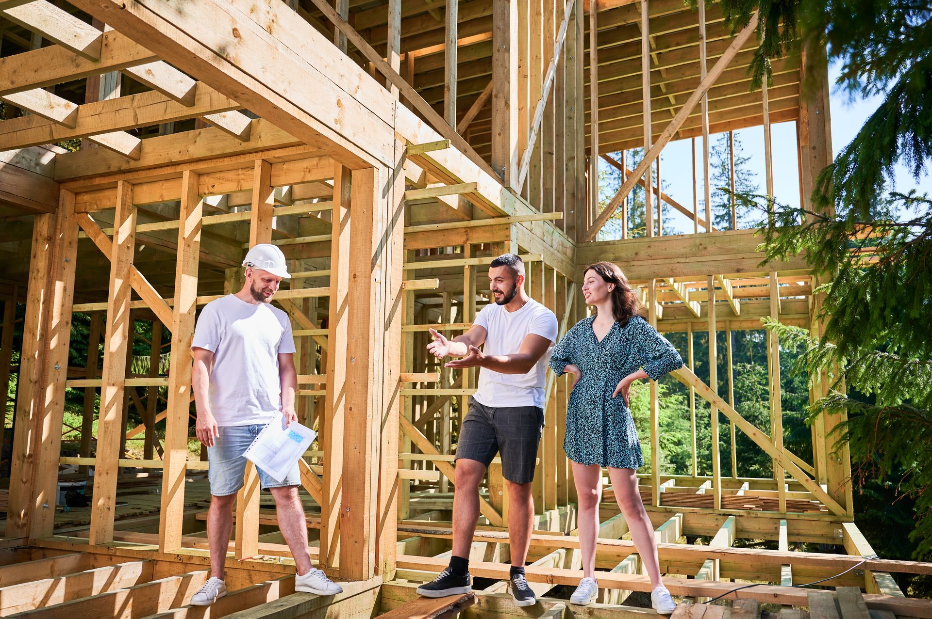 Contractor and homeowners discuss plans at a framed home construction site in Ozark, Missouri.