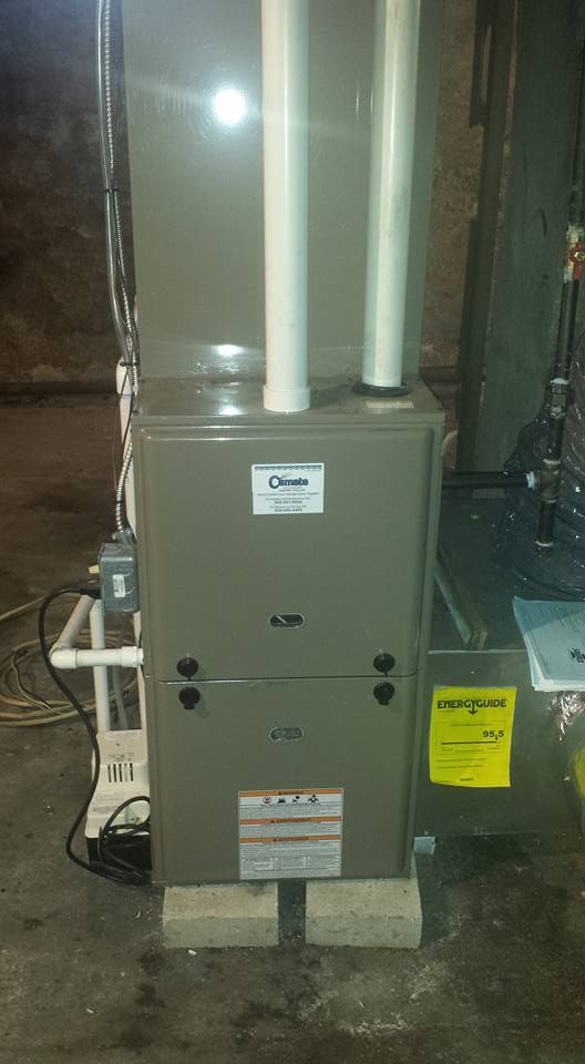 Basement furnace and HVAC ductwork beside a water heater in a utility room