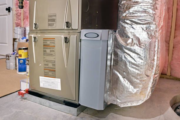 Home HVAC unit beside insulated ductwork in a basement or utility room
