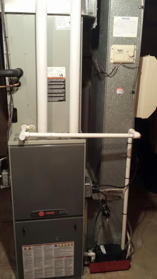 Furnace and HVAC ductwork in a utility closet, with metal panels and pipes