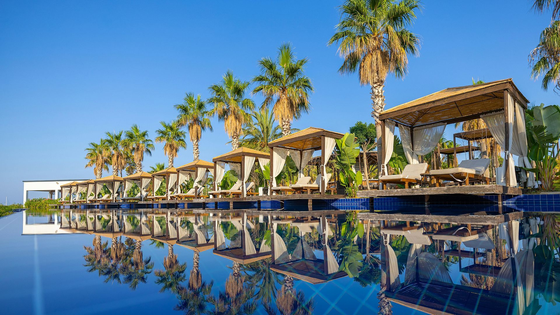 Cabana and palm trees by a pool in a resort in Didim, Turkey