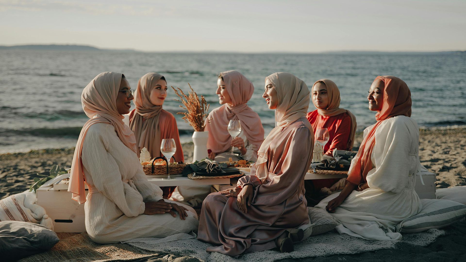 Muslim women relaxing together on a beach at a resort