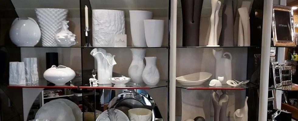 Una vetrina piena di tanti vasi bianchi