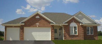 A brick house with a two-car garage under a blue sky with clouds.