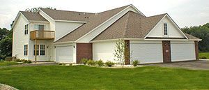 White house with garage and green lawn.