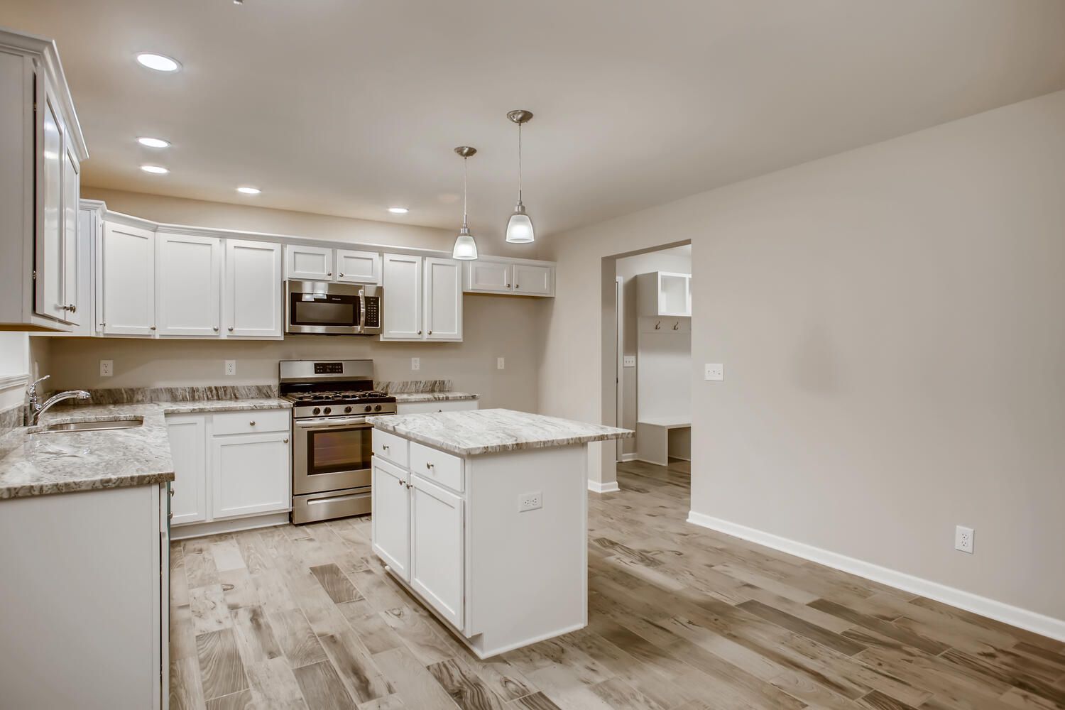Modern kitchen with white cabinets, granite countertops, and a stainless steel stove and oven.