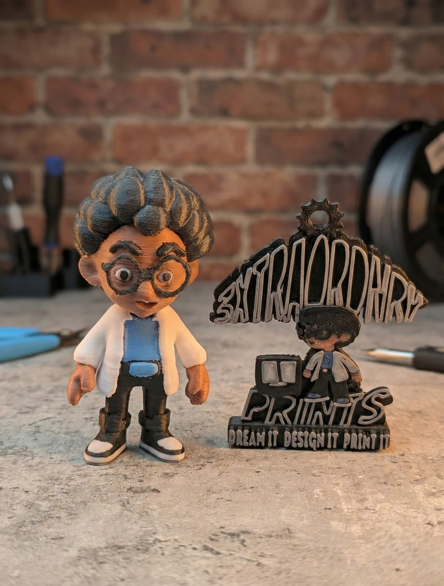 Small handcrafted doll beside a black ornate nameplate on a table, with a brick wall background