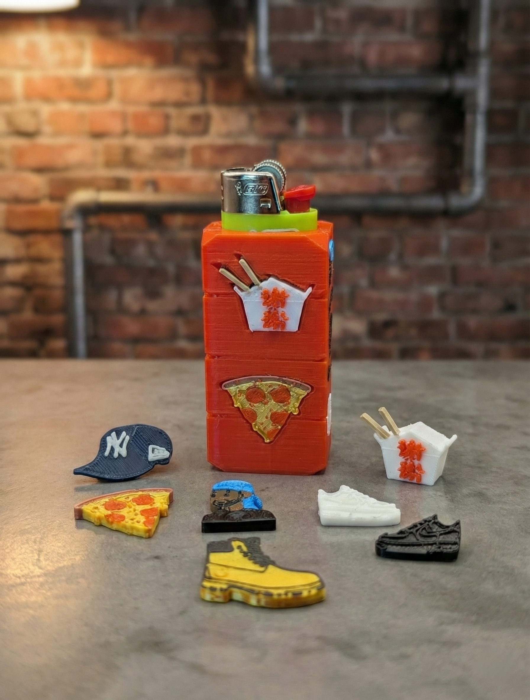Red bottle on concrete with tiny shoes and hats arranged around it against a brick wall.