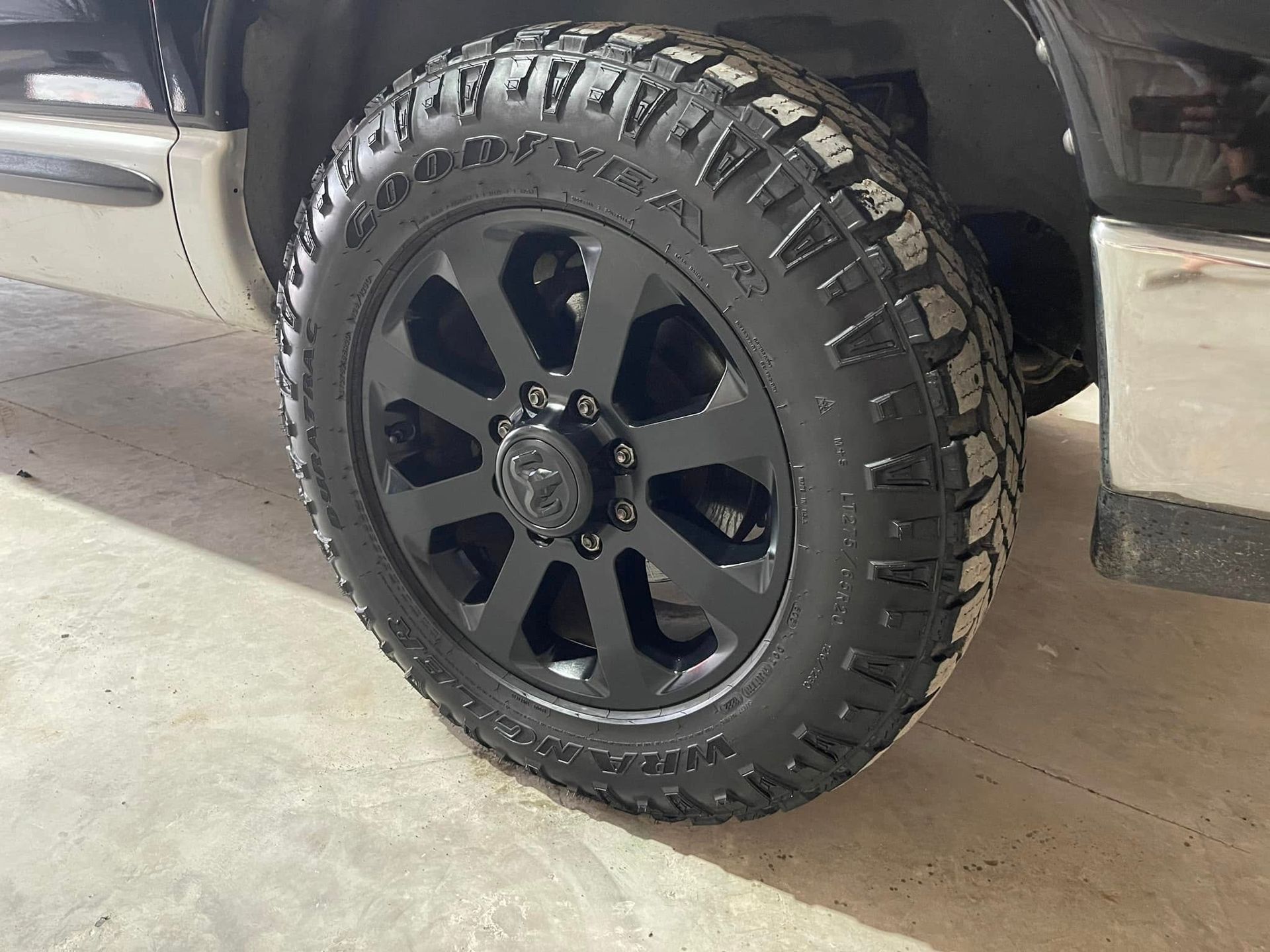 A close up of a black tire on a black truck.