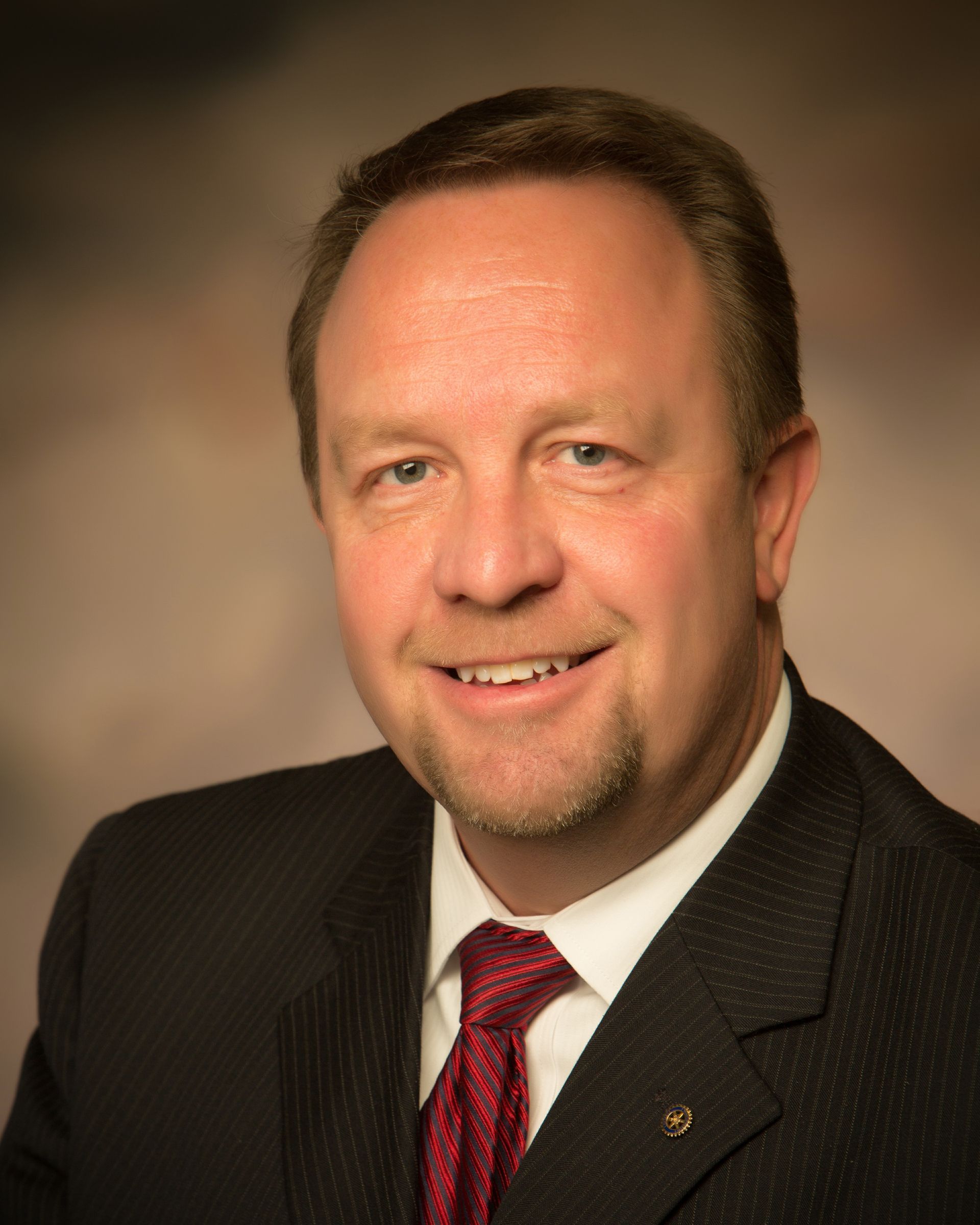 A man in a suit and tie is smiling for the camera.